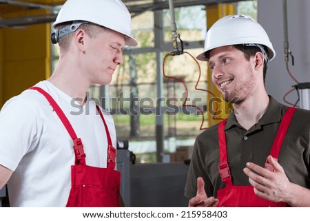Young colleagues from factory discussing during work