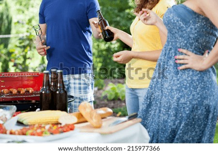 Friends during barbecue in a garden, horizontal