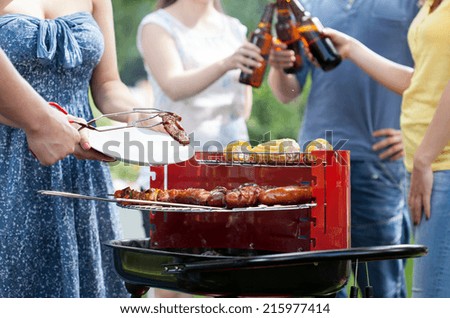 Friends having party with barbecue in a garden