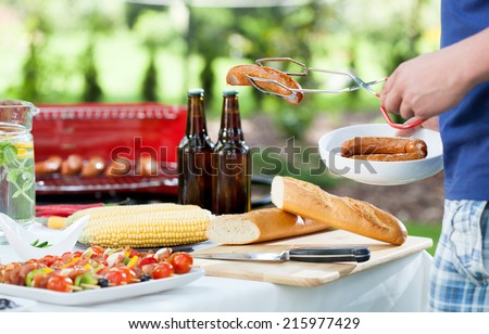 Man during barbecue in a garden, horizontal