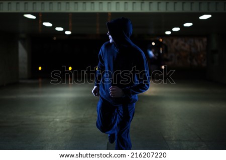 Mugger running in the underpass at night