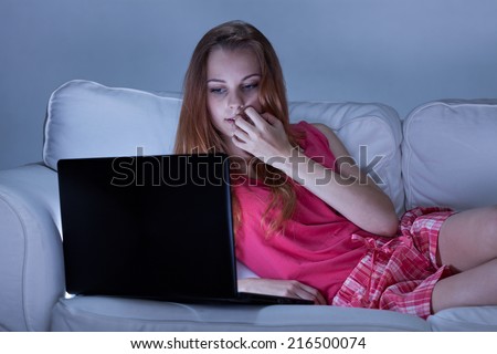 Girl in rose pajamas watching videos online
