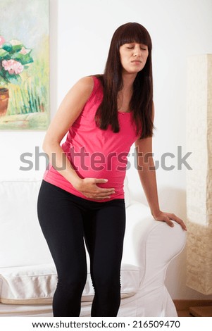 Pregnant woman with strong stomach pain at home