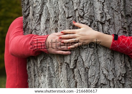 Couple hugging a big tree in the park