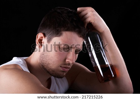Unconscious man with bottle of expensive alcohol