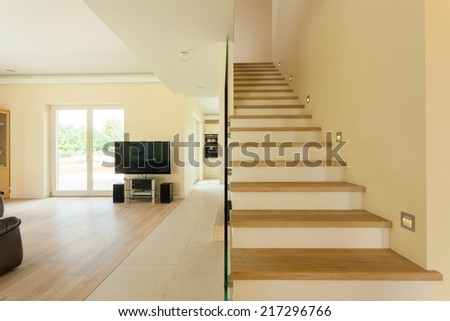 Spacious well lit living room with staircase