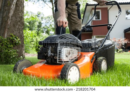 Turning on the lawn mower by gardener