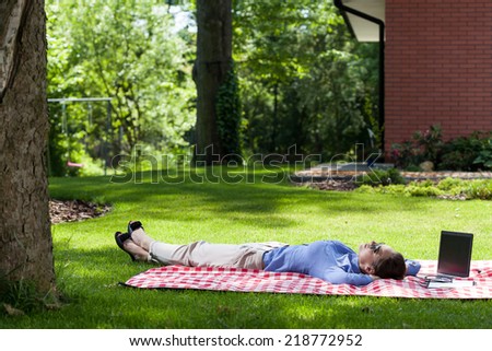Woman relaxing after work on a blanket in her backyard