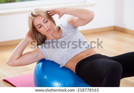 Woman practicing stomach muscles at home, horizontal