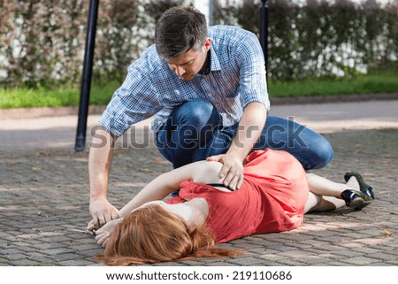 Man lying unconscious girl in recovery position