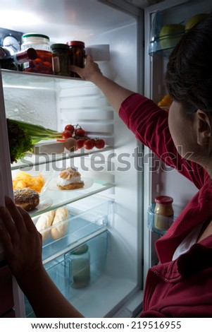 Hungry woman choosing food at the night