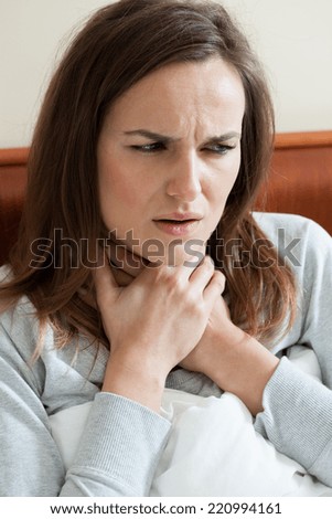 Vertical view of woman feeling sore throat