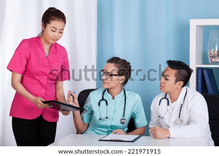 Asian and caucasian doctors during job, horizontal
