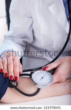 Young doctor measuring a pressure her middle aged patient