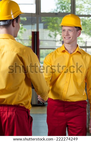 View of workers handshake in a factory