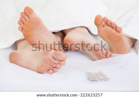 Close up of feet of a happy couple in bed