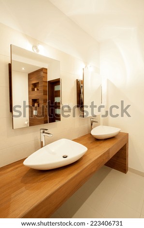 Porcelain sinks on wooden counter in bathroom