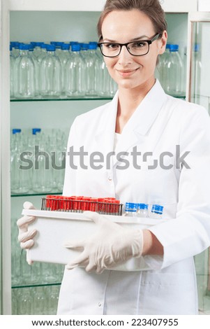 Lab assistant holding box with chemical equipment