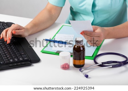 Close-up of doctor\'s hands checking rx paper