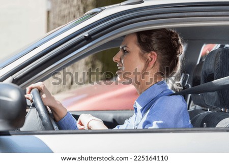 Furious young woman standing in a traffic jam, horizontal