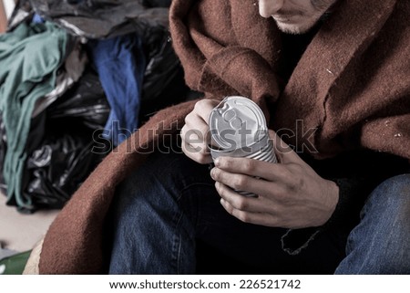Homeless man covered with a blanket eat a meal
