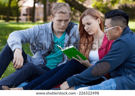 Multi-ethnic friends studying to exam outside