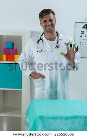 Friendly pediatric doctor with toys inviting kids to visit