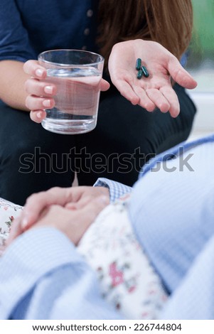 Close-up of female hands giving ill person medicines