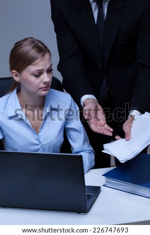 Young worried assistant listening to her boss
