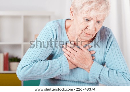 Portrait of elderly woman having heart attack