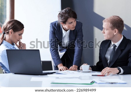 Angry female manager talking with her employees