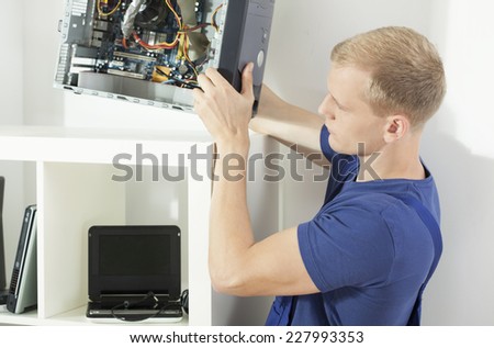 Horizontal view of computer technician repairing computer