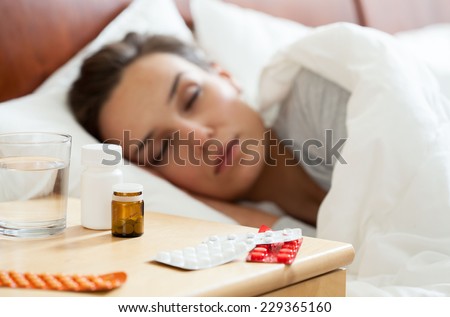Woman lying in bed having autumn flu