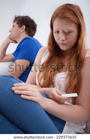 Sad girl after doing of positive pregnancy test