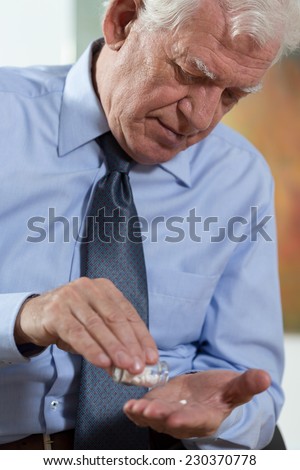 Close-up of elderly dignified man taking the medicine
