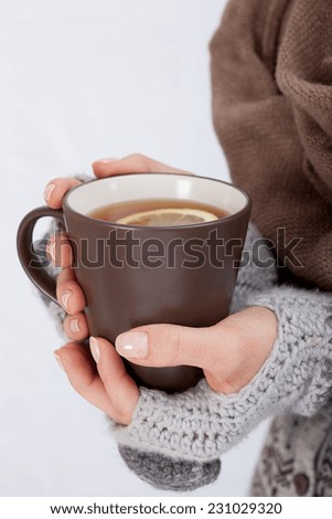 Mug of hot tea in woman\'s hands, vertical