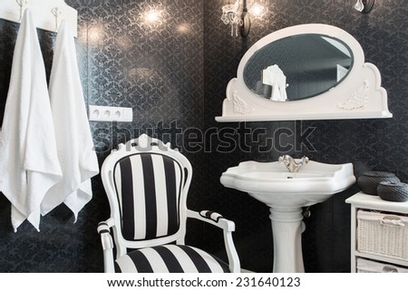 Extravagant bathroom with black wall and white basin