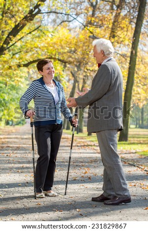 Elderly woman on nordic walking meeting her old friend