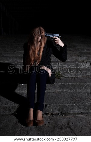 Depressed woman putting gun to her head