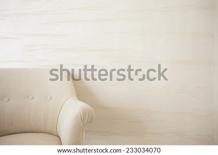 Beige armchair on a background of bright wall