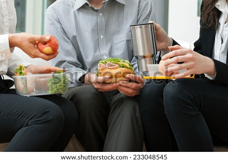 Young businessmen eating homemade lunch during break