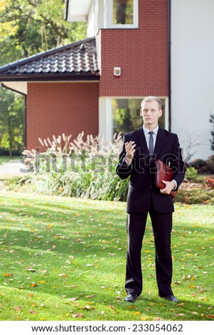 Vertical view of elegant house agent wearing suit