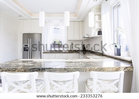 Modern, white kitchen with long granite worktop
