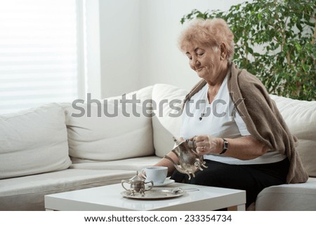 Aged elegant woman drinking her afternoon tea