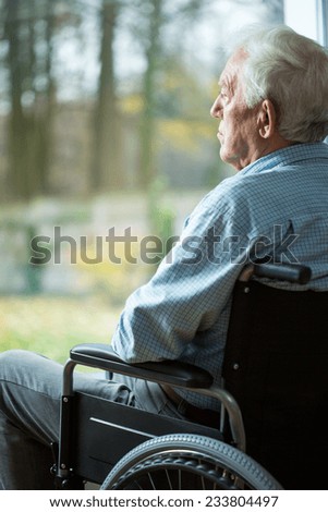 Sad disabled man looking from the window