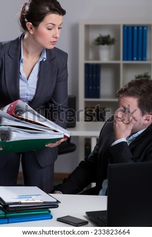 Female boss giving lot of work to her busy worker