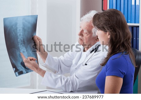 Elderly family doctor and his patient\'s X-ray image