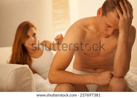 Man having headache sitting on the bed