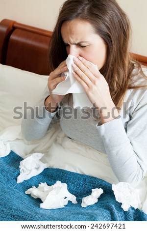 Woman with runny nose and a lot of tissues