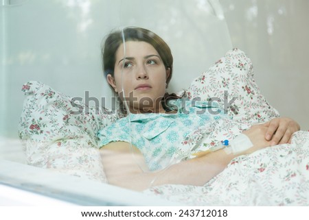 Ill young woman lying in hospital bed